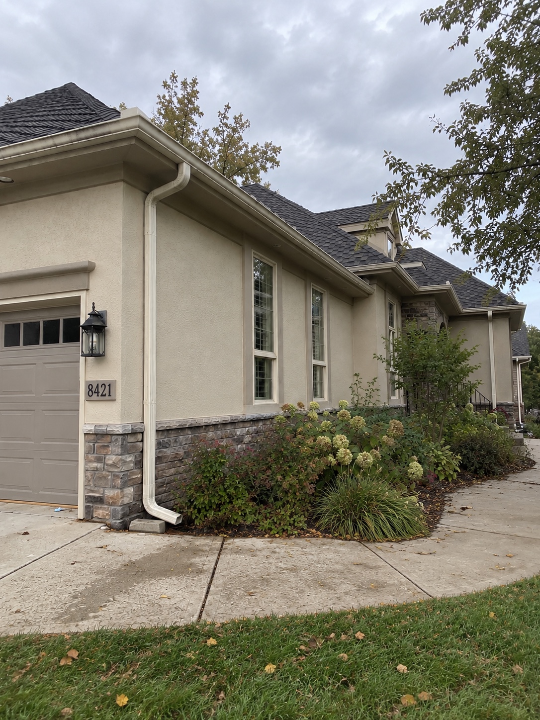 Front exterior with white seamless gutters and a downspout