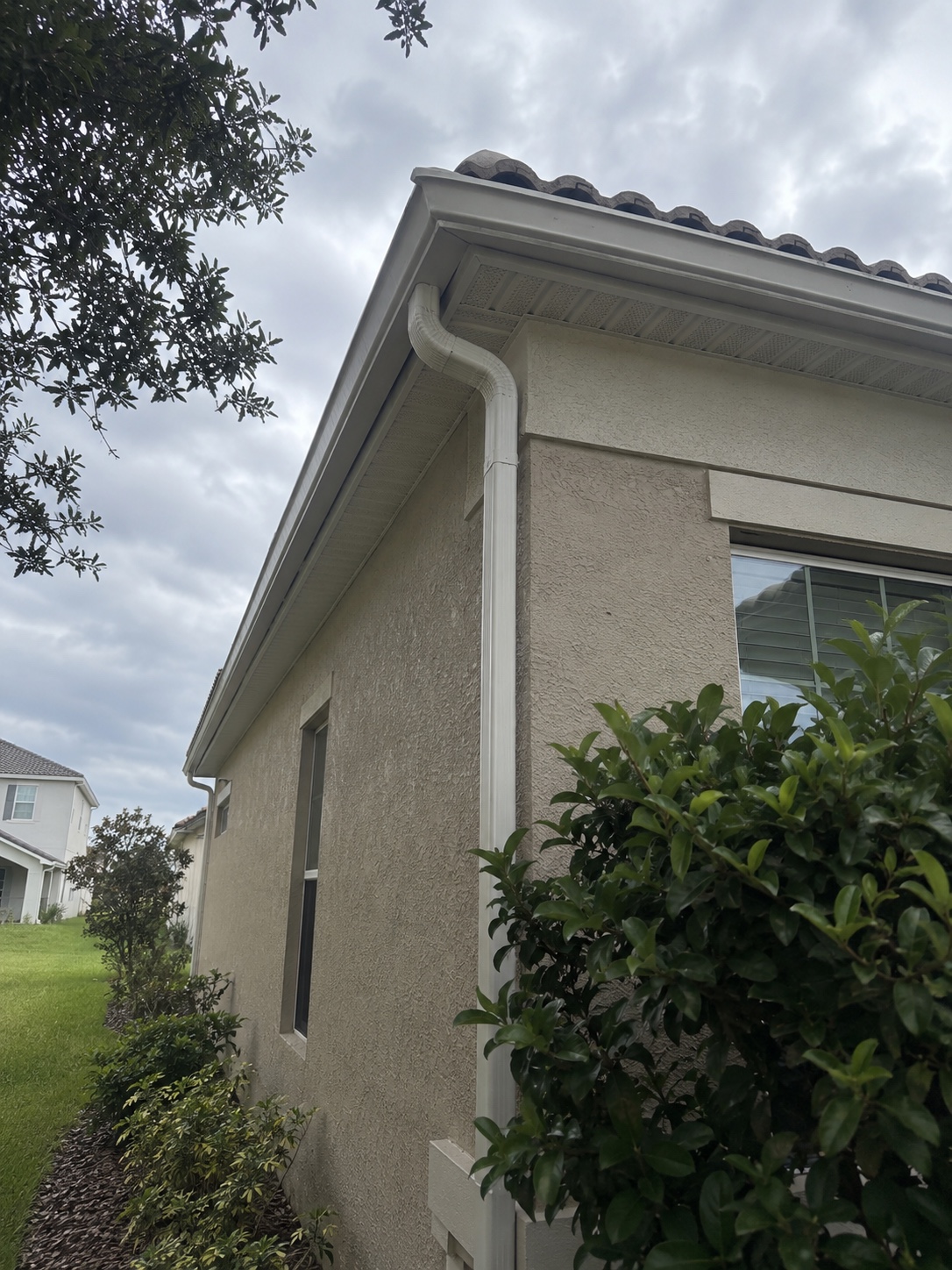 Side roofline with white gutters and a corner downspout