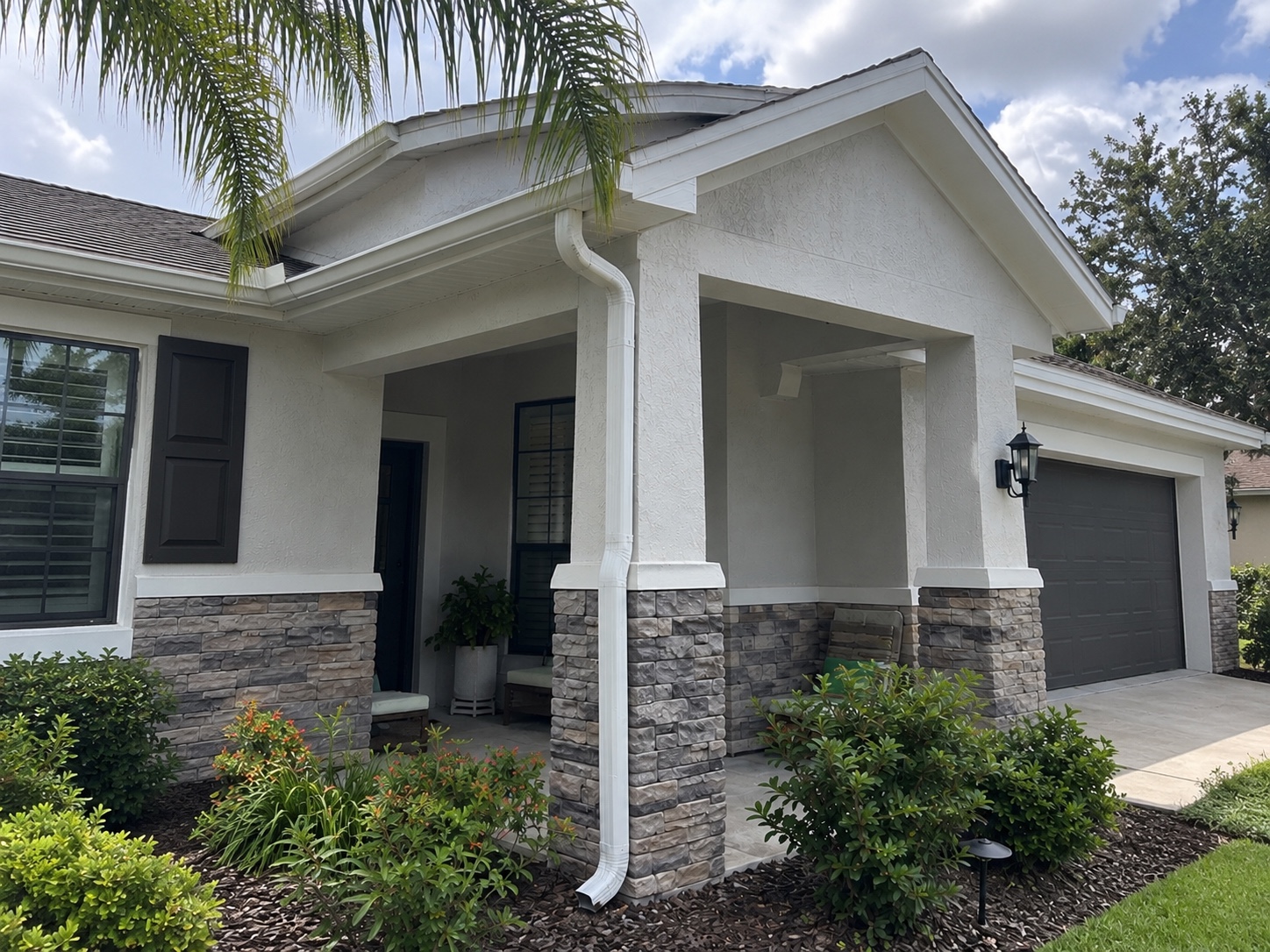 Windermere front porch with replacement white gutters and a downspout