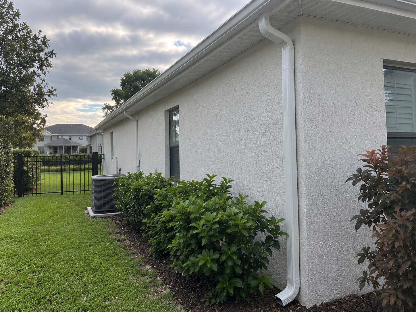 Windermere side exterior with white gutters and a downspout